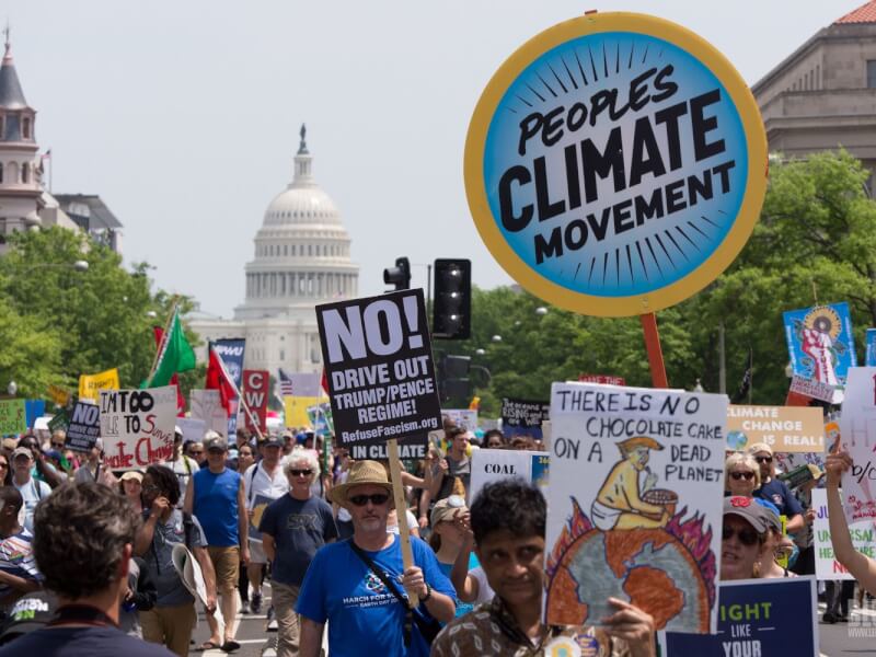 people marching in Washington D.C holding a sign saying Peoples Climate Movement