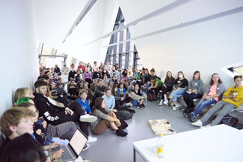 A group of young people in a conference room listening to a workshop or talk