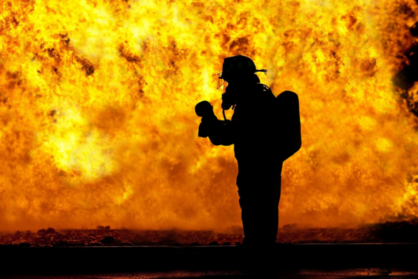 Silhouette of a firefighter against a fire