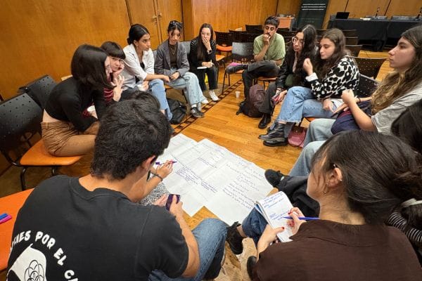 A group of young people sit in a circle deep in conversation