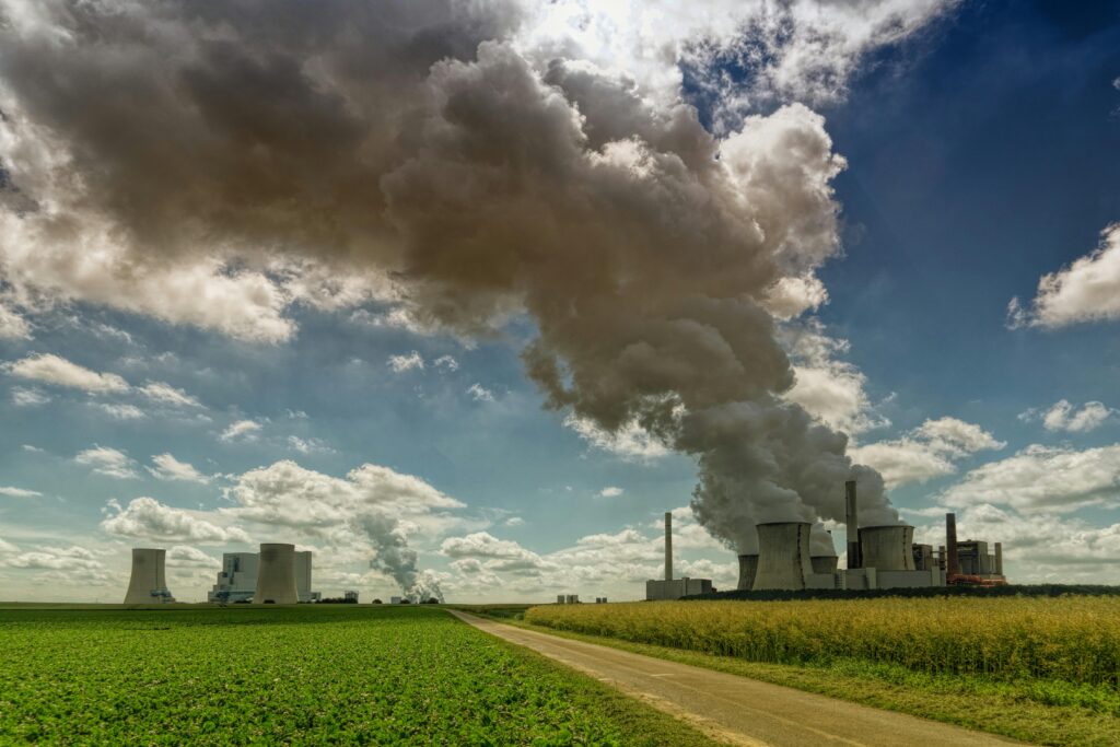 A green field with a coal fired power station.